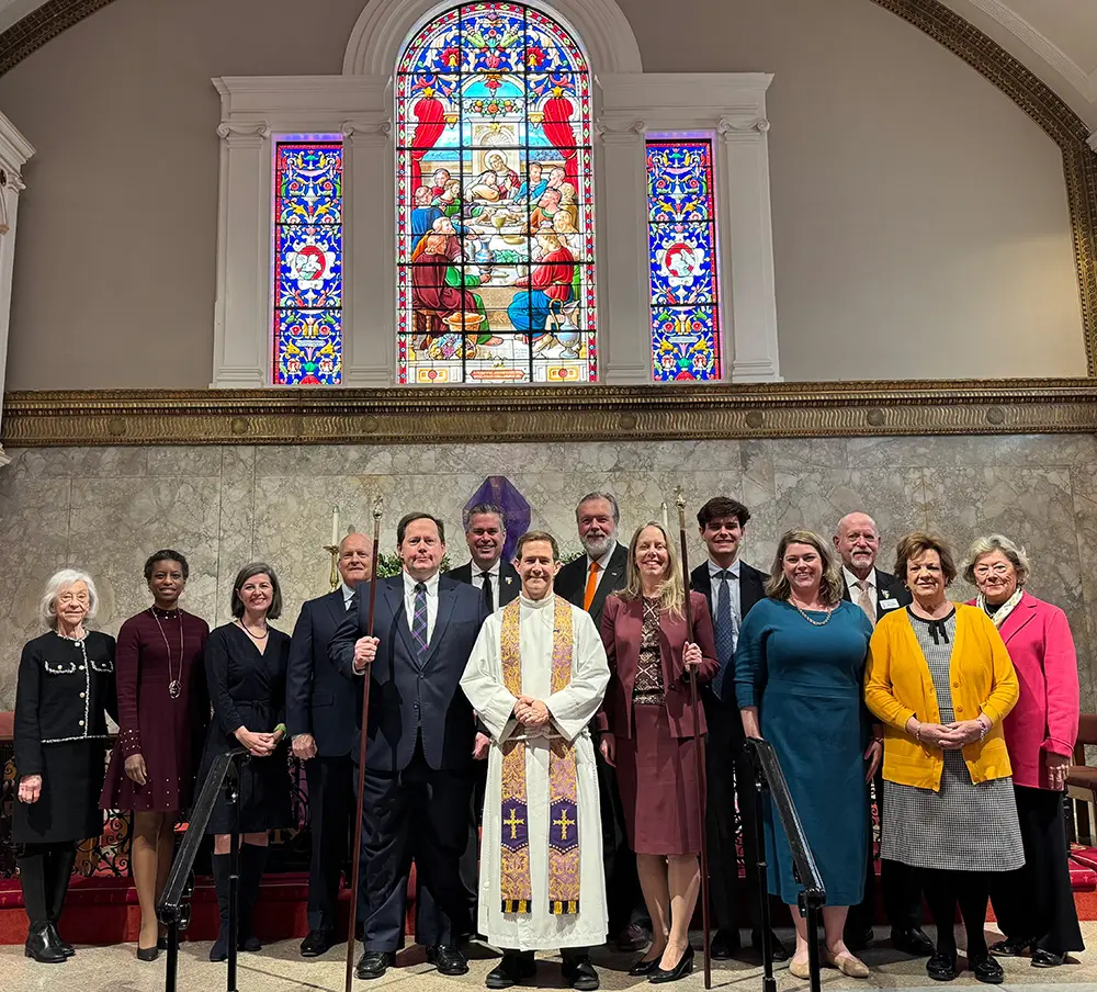 Thirteen smiling members of the 2026 Vestry stand together for a photo in front of the altar.